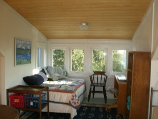 a bedroom with a wall of sunny windows
