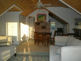 an attic room with sofas and a table and chairs
